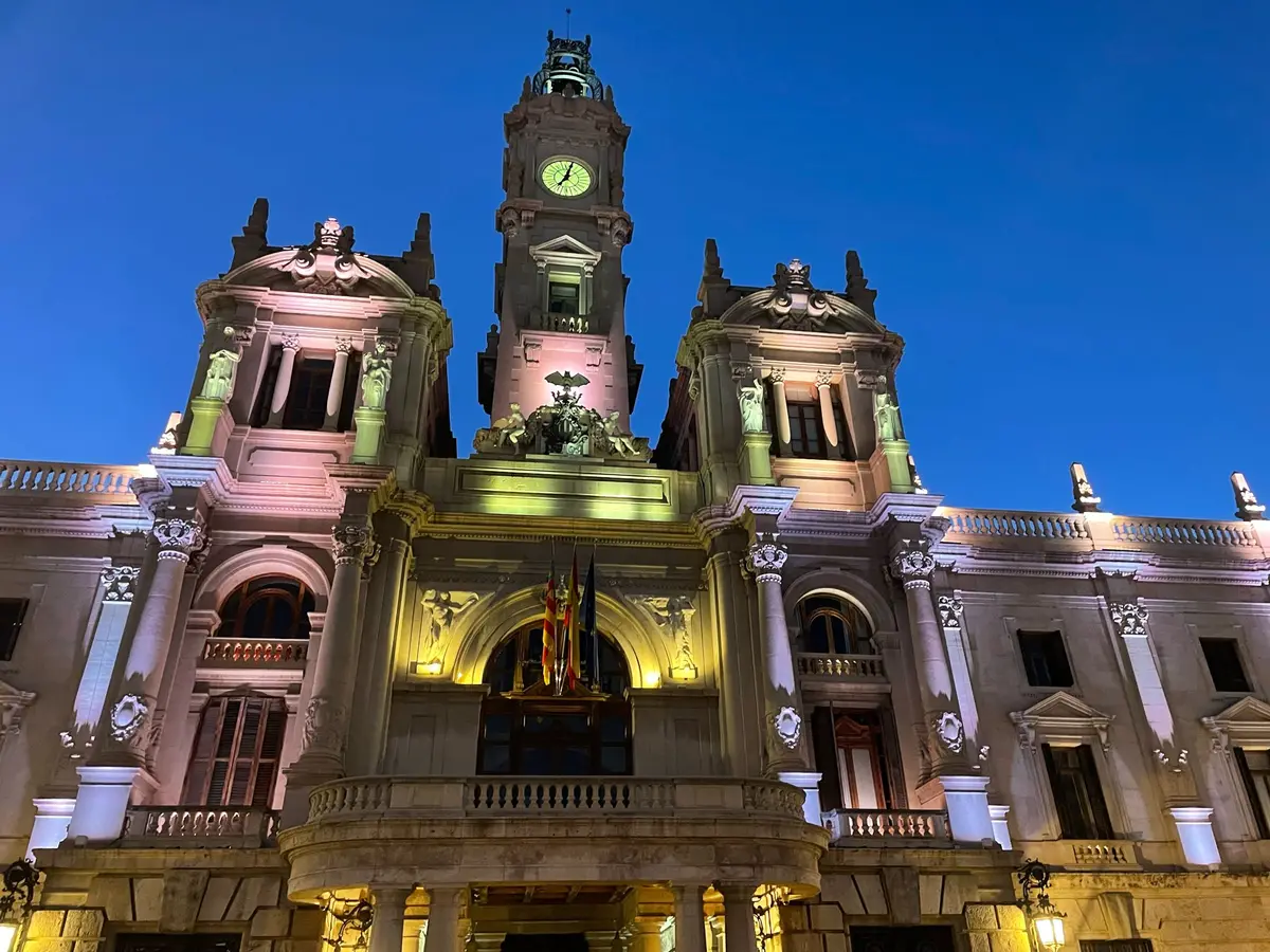 Valencia City Hall facade with its clock tower lit at dusk