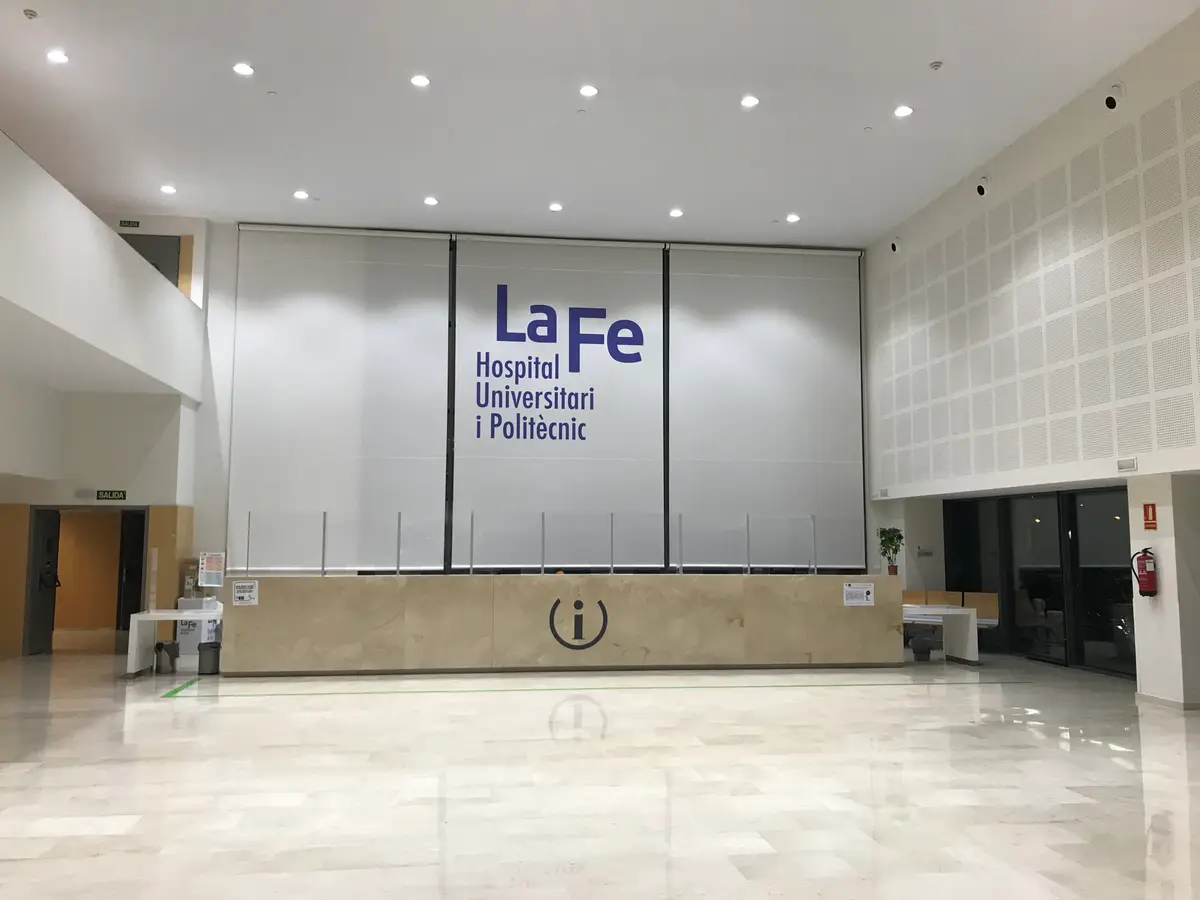Tall entrance hall with a large hospital logo and an information desk